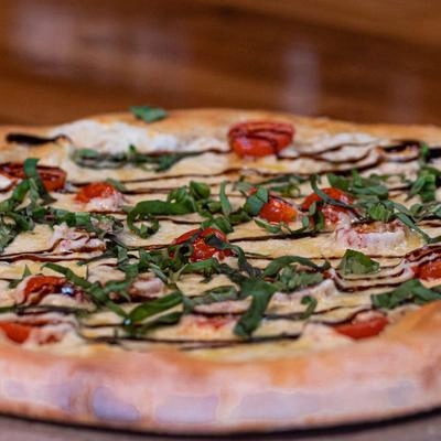 A pizza sitting on top of a wooden table.