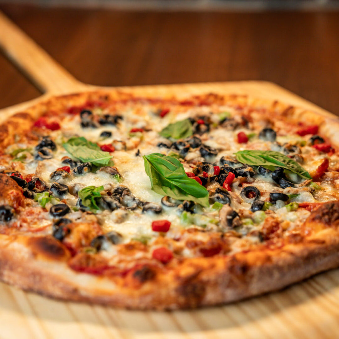 A pizza sitting on top of a wooden board.